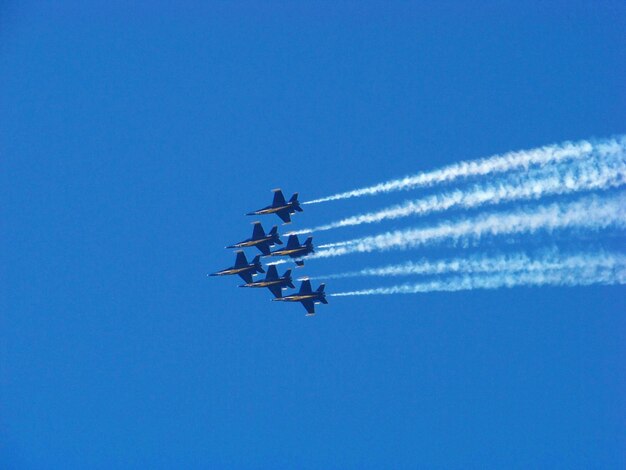 Photo low angle view of airshow against clear blue sky