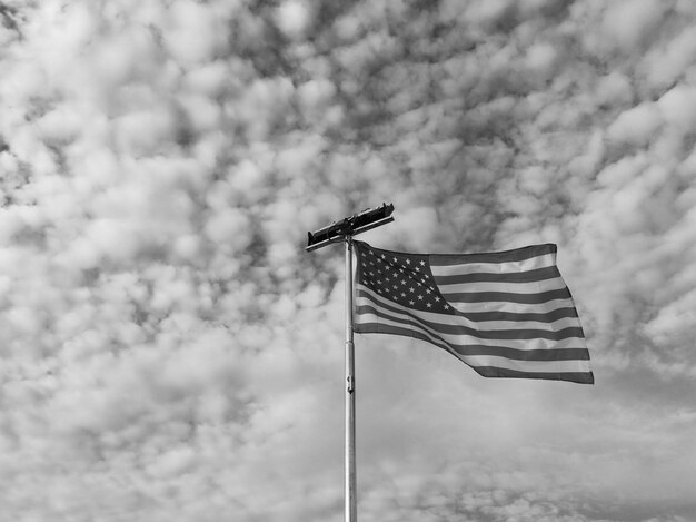 Photo low angle view of american flag against cloudy sky