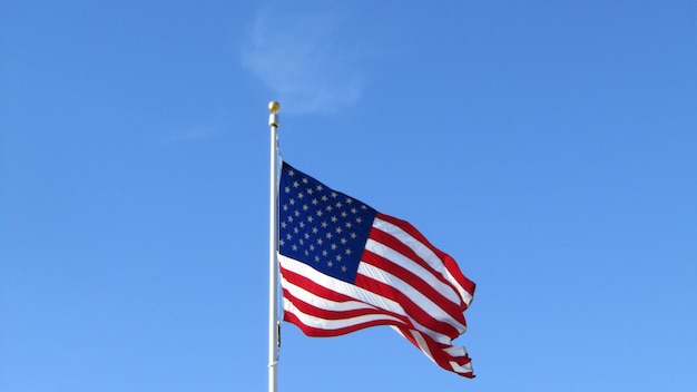 晴れた日に空に照らされたアメリカ国旗の低角度の眺め
