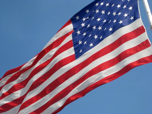 Photo low angle view of american flag waving against clear sky