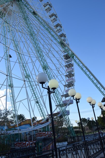 Low angle view of amusement park ride against blue sky