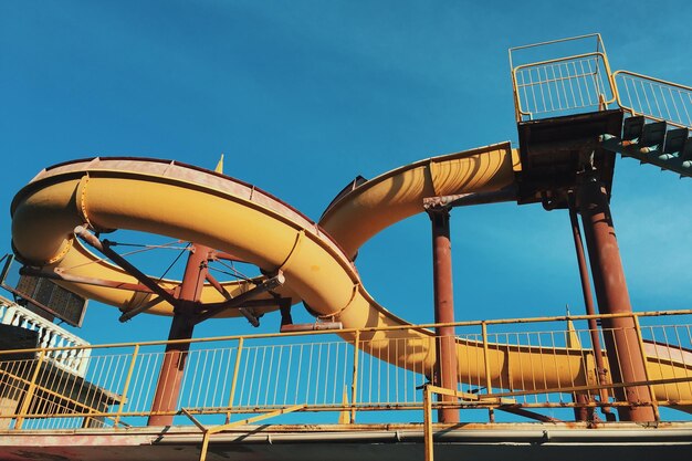 Photo low angle view of amusement park ride against clear blue sky