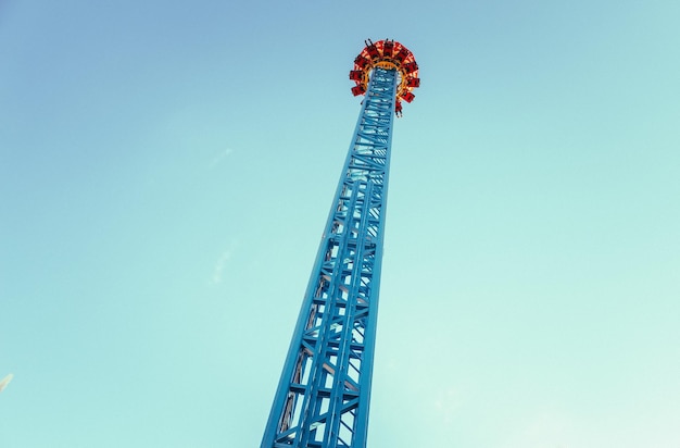 Photo low angle view of amusement park ride against clear blue sky