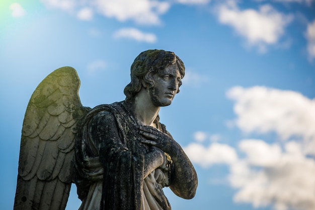 Photo low angle view of ancient angel statue against sky