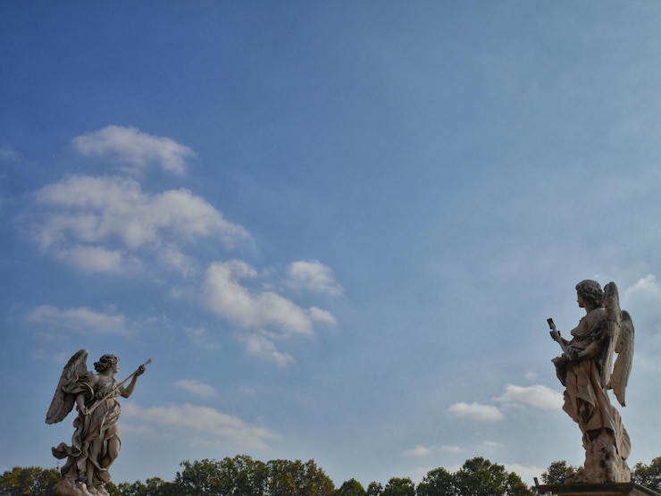 Photo low angle view of angel sculptures against sky
