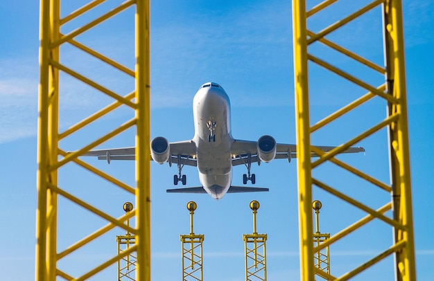 Foto veduta a basso angolo del sistema di illuminazione di avvicinamento rispetto all'atterraggio dell'aereo all'aeroporto