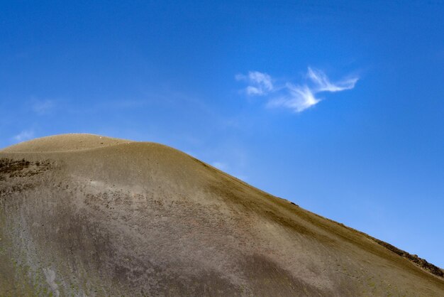 Low angle view of arid landscape of mountain against blue sky and clouds like bird mt asama