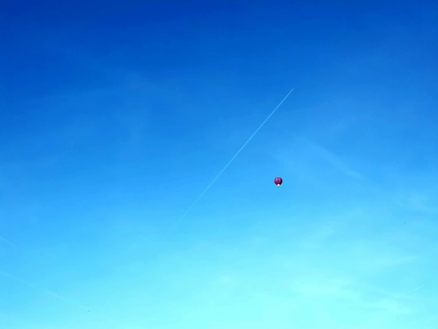 Low angle view of a ballon flying against blue sky