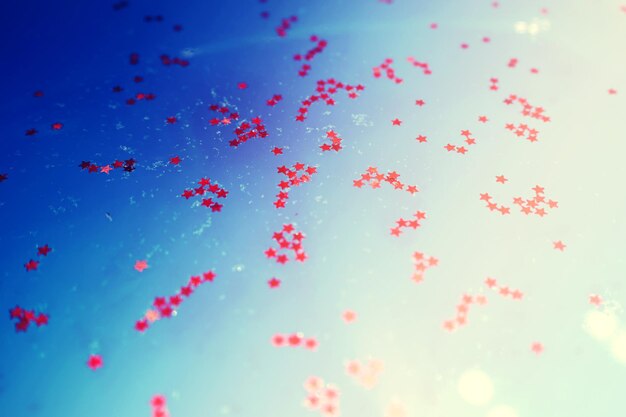 Low angle view of balloons flying against blue sky