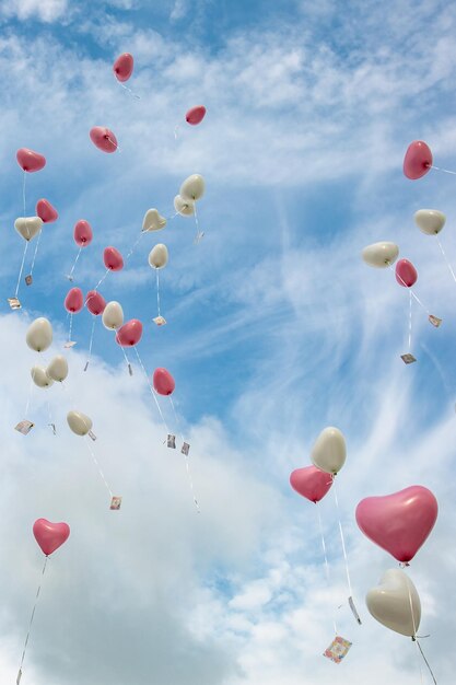 Photo low angle view of balloons flying against sky