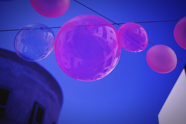 Foto vista a bassa angolazione dei palloncini appesi contro il cielo blu limpido