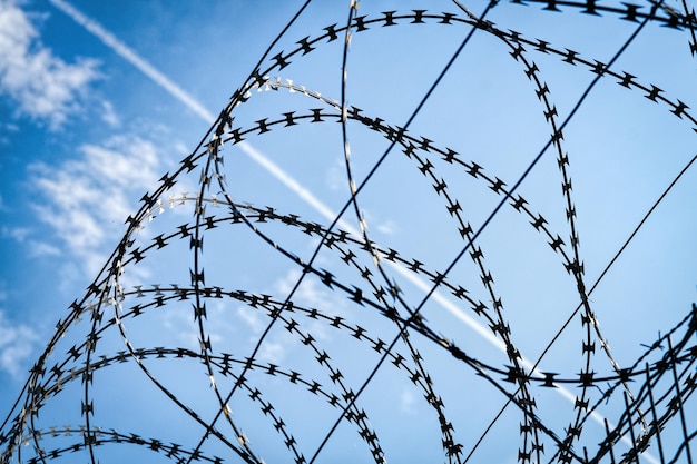 Low angle view of barbed wire against sky