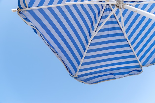 Foto vista a basso angolo dell'ombrello di spiaggia contro un cielo blu limpido