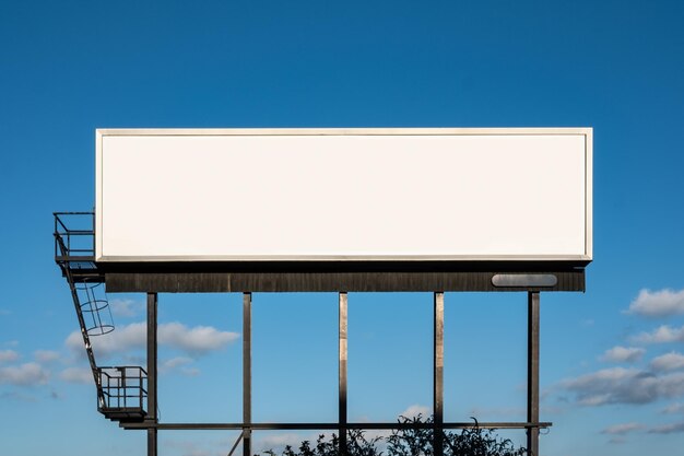 Low angle view of blank billboard against clear blue sky