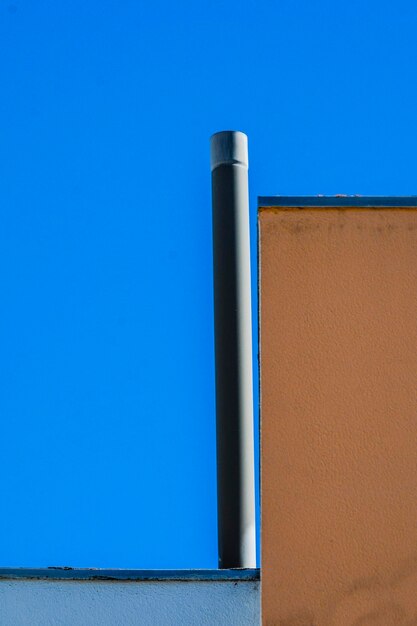 Low angle view of blue wall against clear sky