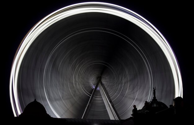 暗い空を背景にぼんやりしたフェリーの車輪の低角度の眺め