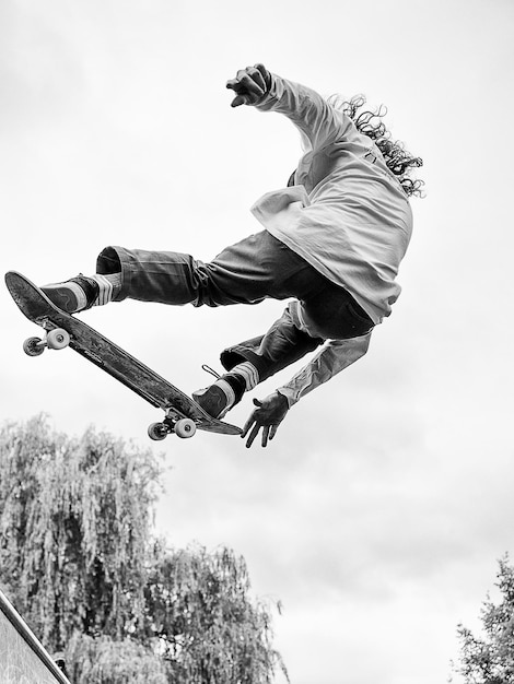 Low angle view of boy jumping against sky