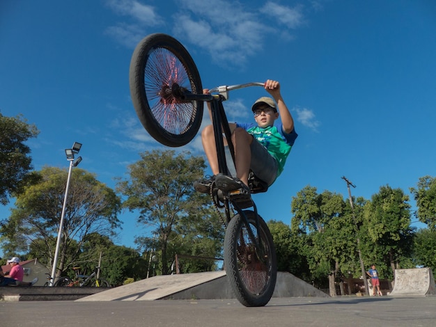 Photo low angle view of boy riding bicycle against sky