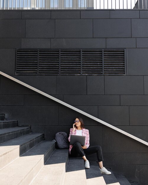 Photo low angle view of boy sitting on staircase