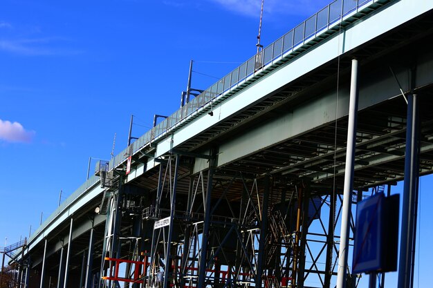 Low angle view of bridge by building against sky