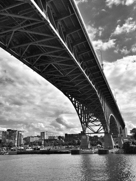 Photo low angle view of bridge over river in city against sky