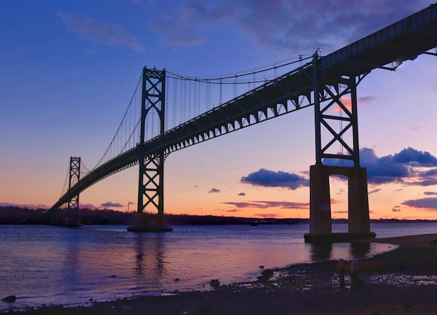 Low angle view of bridge over river during sunset