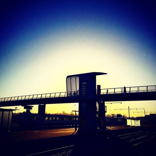 Low angle view of bridge over road against clear sky