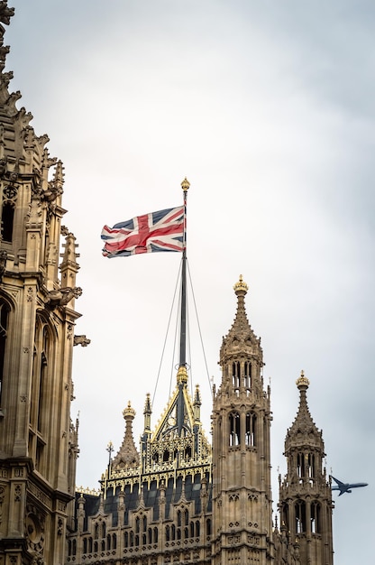 天空を背景に議会の建物上のイギリス国旗の低角度のビュー