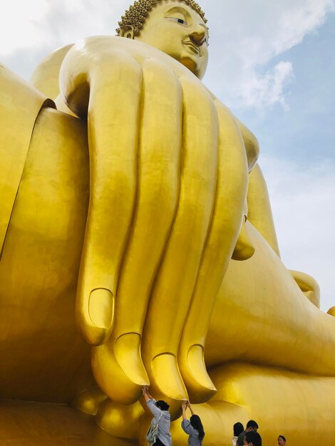 Photo low angle view of buddha statue against sky