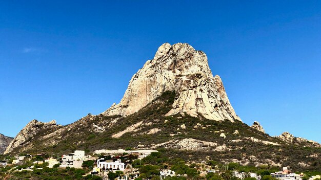 Low angle view of building against mountain range against clear blue sky