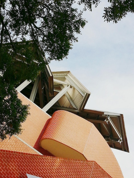 Low angle view of building and tree against sky