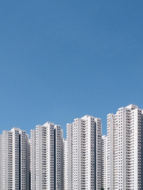 low angle view of buildings against clear blue sky during sunny day