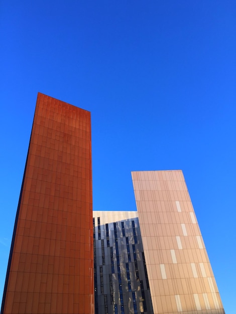 Low angle view of buildings against clear blue sky