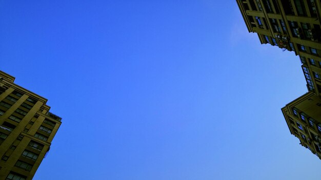 Low angle view of buildings against clear blue sky