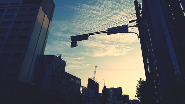 Low angle view of buildings against cloudy sky during sunset