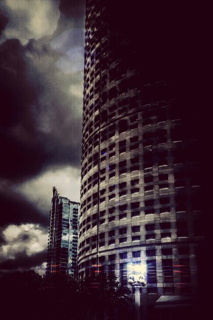 Photo low angle view of buildings against cloudy sky