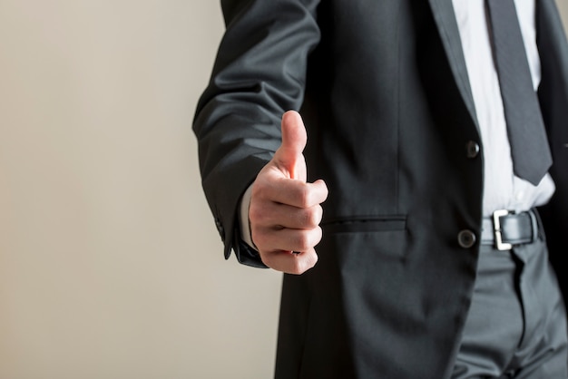 Low angle view of businessman showing a thumbs up sign