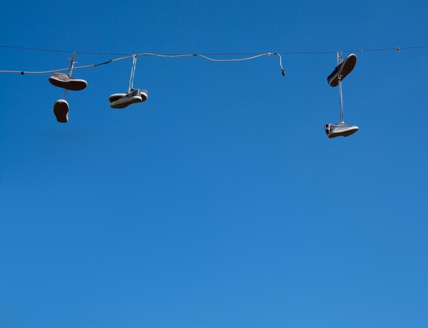 Low angle view of cables against clear blue sky