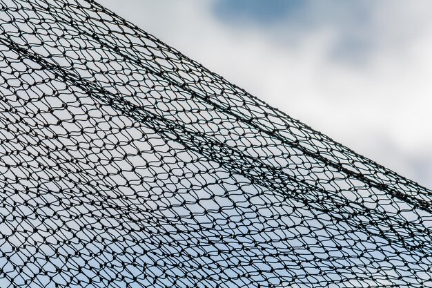 Low angle view of chainlink fence against sky