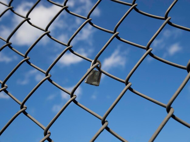 Low angle view of chainlink fence against sky