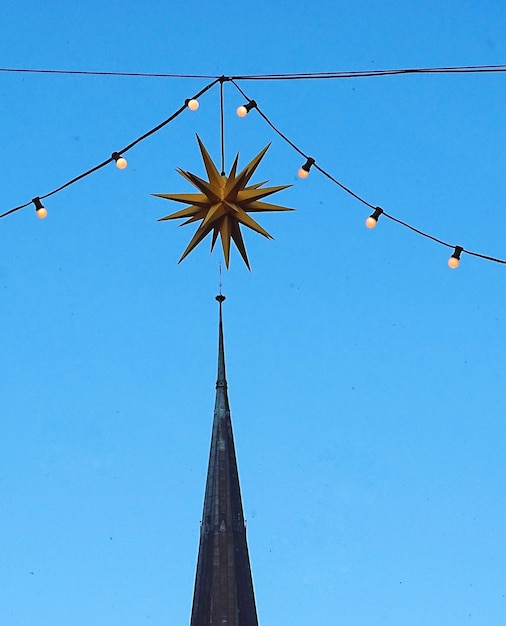 Foto vista a basso angolo delle luci di natale contro un cielo blu limpido