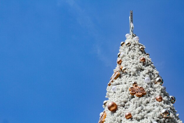 Low angle view of christmas tree against blue sky