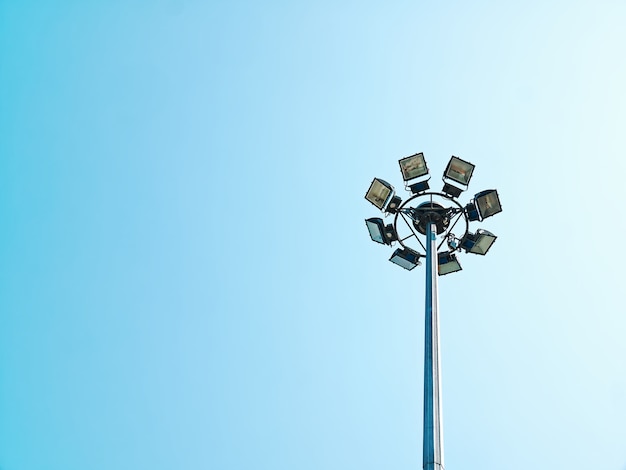 Photo low angle view of circular lamps at top of the post against clear blue sky