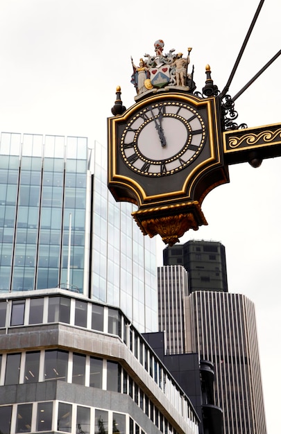 Photo low angle view of clock against buildings in city