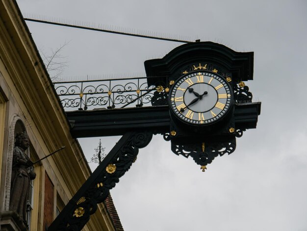 Low angle view of clock against sky