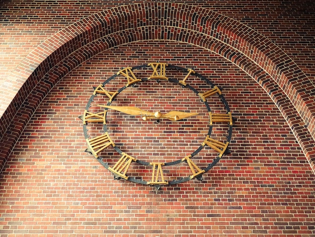 Low angle view of clock mounted on brick wall