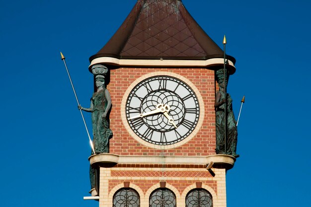 Low angle view of clock tower against clear blue sky