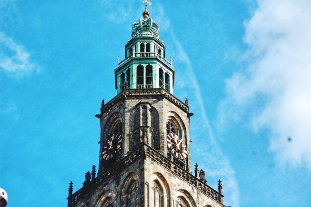 Low angle view of clock tower amidst buildings against sky