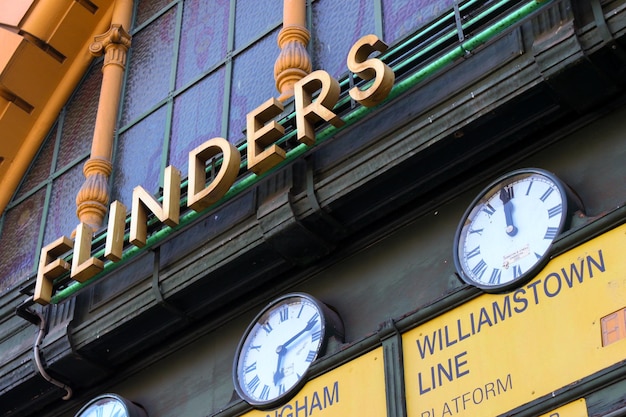 low angle view of clocks and signs on wall at flinders street railway station