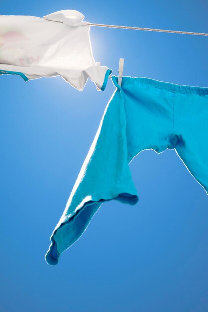 Low angle view of clothes drying against blue sky